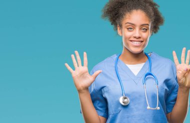 Genç afro Amerikalı doktor kadın gösterilen ve parmakları ile işaret izole arka plan yüzünden kendinden emin ve mutlu gülümseyerek süre sekiz numara.