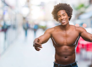 Çıplak vücut sarılmak için kollarını açarak gülümseyerek kameraya bakarak izole arka plan üzerinde gösterilen Afro Amerikalı gömleksiz adam. Neşeli ifade kucaklayan mutluluk.