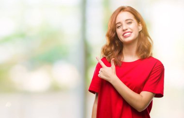 İzole arka neşeli bir gülümseme ile el ve parmak kadar kameraya bakarak yüzündeki mutlu ve doğal ifade ile yan ile işaret yüz genç güzel kadın.