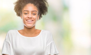 İzole arka plan mutlu yüz çapraz silah kameraya bakarak ile gülümseyen genç afro Amerikalı kadın. Olumlu bir kişi.