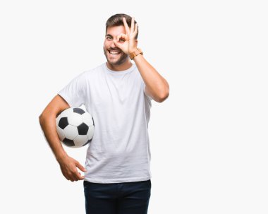 Mutlu yüz el parmaklarının arasından seyir göz üzerinde ok işaretiyle yapıyor gülümseyen izole arka plan üzerinde futbol futbol topu tutan genç yakışıklı adam