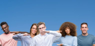 Mavi blackground ile büyük ve büyük boy işaret, ölçü birimi sembol gösteren el eller üzerinde arkadaş grubu bileşimi. Kameraya bakarak gülümsüyordu. Ölçüm kavramı.