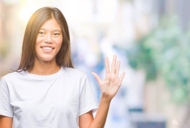 Genç Asyalı kadın gösterilen ve parmakları ile işaret izole arka plan üzerinde beş kendinden emin ve mutlu gülümseyerek iken numara.