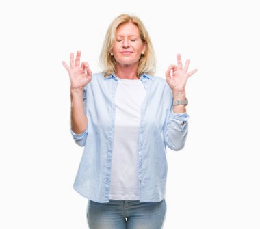 Orta yaş sarışın kadın izole arka plan üzerinde dinlenmek ve gülümseyen gözlerle parmak ile meditasyon jest yapıyor kapalı. Yoga kavramı.