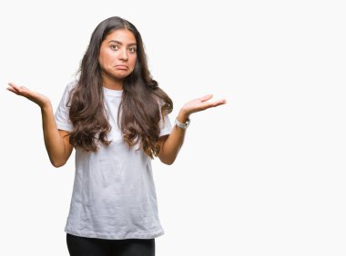 Genç güzel Arap kadın izole arka plan clueless ve şaşkın bir ifadeyle kollar ve eller kaldırdı. Şüphe kavramı.