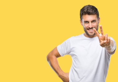 Arka planda kalan yakışıklı genç adam kameraya bakıp zafer işareti yaparken gülümsüyor. İki numara..