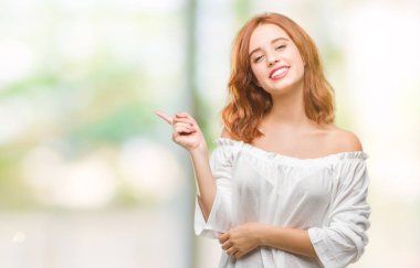 Kameraya bakarak yan el ve parmak ile işaret izole arka yüzünde kocaman bir gülümseme ile genç güzel kadın.