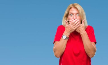 Orta yaş sarışın kadın izole arka plan ağız hata için elleriyle kapsayan şok yüzünden. Gizli kavramı.