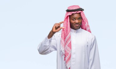 Geleneksel keffiyeh izole arka plan gülümseyen ve süre seyir ve kamera boyutu işaret parmaklarıyla yapıyor el ile kendinden emin eller üzerinde giyen genç Arapça Afrika adam. Ölçü kavramı.