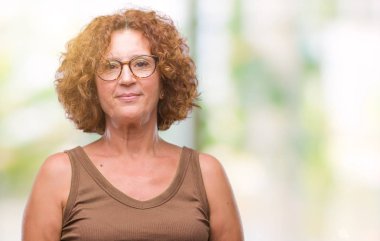 Orta yaş İspanyol kadın yüzünde ciddi bir ifade ile izole arka plan üzerinde gözlük takıyorum. Basit ve doğal kameraya bakıyor.