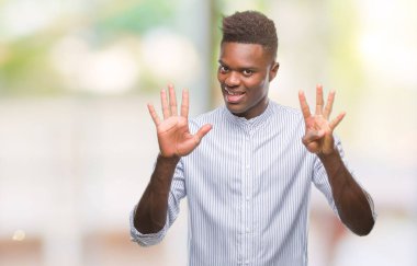 Genç Afro-Amerikan adam gösterilen ve parmakları ile işaret izole arka plan üzerinde numara 9 kendinden emin ve mutlu gülümseyerek süre.