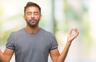 İzole arka plan yetişkin İspanyol adam rahatla ve gülümseyen gözlerle kapalı parmak jestle meditasyon yapıyor. Yoga kavramı.