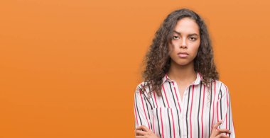 Güzel genç İspanyol kadın şüpheci ve sinir, onaylamayan ifade yüz çapraz kolları üzerinde. Negatif kişi.