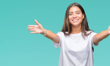 Genç güzel Arap kadın sarılmak için kollarını açarak gülümseyerek kameraya bakarak izole arka plan yüzünden. Neşeli ifade kucaklayan mutluluk.