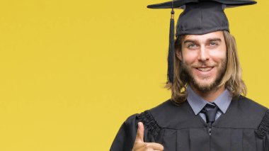 Genç yakışıklı adam uzun saçlı hareketi el ile mutlu yaşasın yapıyor izole arka plan üzerinde mezun oldu. Kameraya bakarak başarı gösteren ile ifade onaylama.