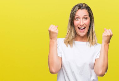 İzole arka plan kutlama üzerinde genç güzel kadın şaşırttı ve başarı için kaldırdı kollarını açarak hayret ve gözleri açık. Kazanan kavramı.