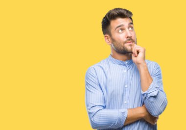 Yakışıklı delikanlı çene düşünme hakkında soru, dalgın ifade üzerine el ile izole arka plan üzerinde. Düşünceli yüzüyle gülümsüyor. Şüphe kavramı.