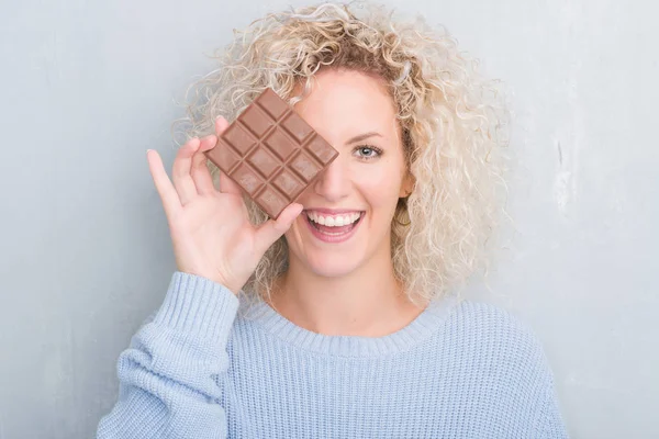 Junge Blonde Frau Über Grunge Graue Wand Essen Schokoladentafel Mit — Stockfoto