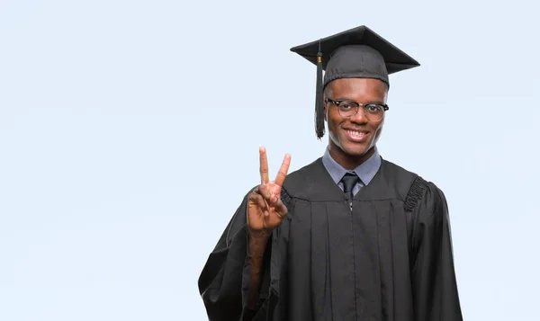 年轻毕业的非洲裔美国人在孤立的背景显示和指向手指第二 而微笑着自信和快乐 — 图库照片