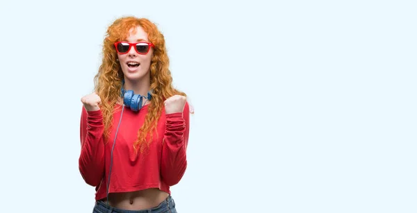 Νέοι Κοκκινομάλλα Γυναίκα Που Φοράει Ακουστικά Ουρλιάζοντας Περήφανος Και Γιορτάζει — Φωτογραφία Αρχείου