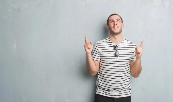 Joven Caucásico Hombre Sobre Gris Grunge Pared Asombrado Sorprendido Mirando — Foto de Stock