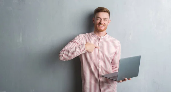 Joven Pelirrojo Hombre Sobre Gris Grunge Pared Celebración Uso Ordenador — Foto de Stock