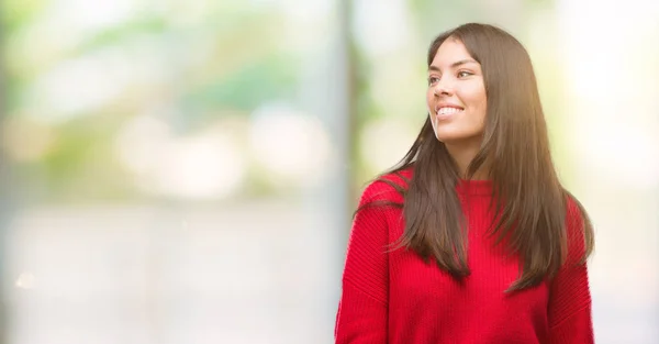 Joven Hermosa Hispana Vistiendo Suéter Rojo Mirando Hacia Otro Lado —  Fotos de Stock