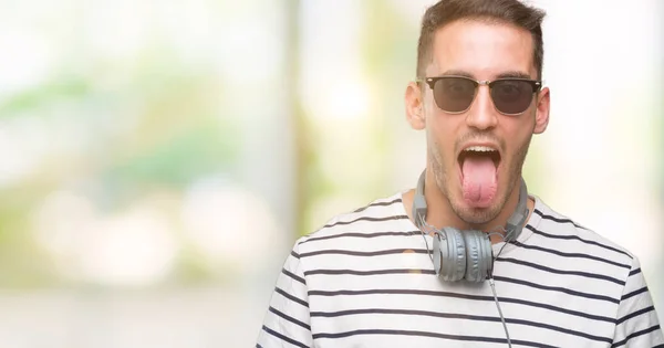 Bonito Jovem Vestindo Fones Ouvido Furando Língua Feliz Com Expressão — Fotografia de Stock