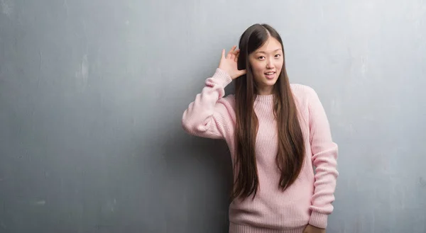 Jovem Chinesa Sobre Parede Cinzenta Sorrindo Com Mão Sobre Orelha — Fotografia de Stock