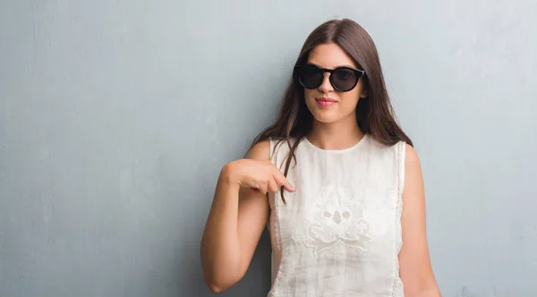 Young Brunette Woman Grunge Grey Wall Wearing Fashion Sunglasses Surprise — Stock Photo, Image
