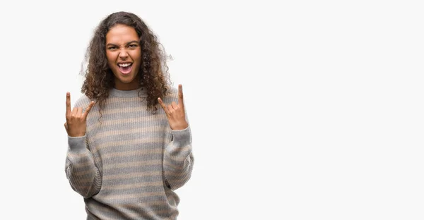 美しい若いヒスパニック系女性を手でロックのシンボルをやってクレイジー式ストライプ セーター叫び身に着けています 音楽の星 重いコンセプト — ストック写真