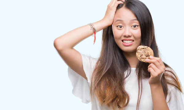 Jovem Mulher Asiática Comendo Biscoito Chocolate Sobre Fundo Isolado Estressado — Fotografia de Stock