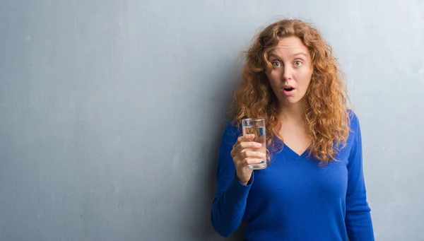 Young Redhead Woman Grey Grunge Wall Drinking Water Scared Shock — Stock Photo, Image