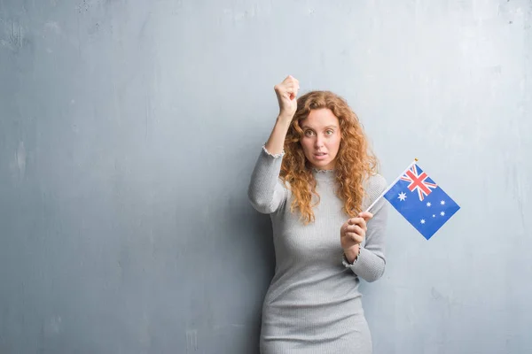 Joven Pelirroja Sobre Pared Grunge Gris Sosteniendo Bandera Australia Molesta —  Fotos de Stock