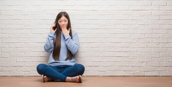 沈黙の中 秘密の概念で怖がっている恐怖の表現 間違いのための恥とショックを受けた手でレンガ壁カバー口を床に座って若い中国の女性 — ストック写真