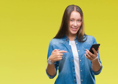 Genç güzel beyaz kadın manifatura sürpriz yüz işaret parmağı kendini izole arka plan üzerinde Smartphone kullanarak ileti gönderme