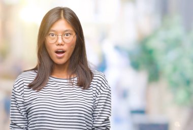 Korkuyor ve şok sürpriz ifade, korku ve heyecan yüz ile izole arka plan üzerinde gözlük takan Genç Asyalı kadın.