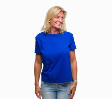 Orta yaş sarışın kadın izole arka plan uzak tarafına gülümseme ile yüzünde, doğal ifade seyir üzerinde. Kendine güvenen gülüyor.