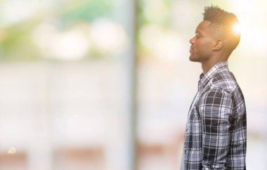 İzole arka tarafına, arayan genç Afro-Amerikan adam sakin ol kendine güvenen gülümseme ile doğal yüz pozuyla profili.