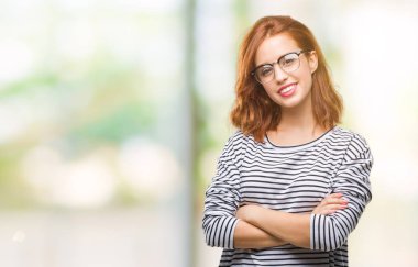 İzole arka plan gözlük mutlu yüz çapraz silah kameraya bakarak ile gülümseyen giyen genç güzel kadın. Olumlu bir kişi.