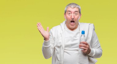 Yakışıklı komuta sizde eğitim holding havlu ve su şişesi üzerinde kocaman bir gülümseme ile çığlık zaferini kutluyor ve ellerini kaldırdı izole arka plan çok mutlu ve heyecanlı, kazanan ifade