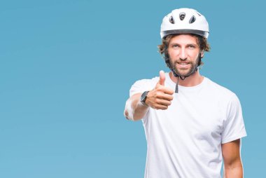 Yakışıklı İspanyol bisikletçi erkek hareketi el ile mutlu yaşasın yapıyor izole arka plan üzerinde güvenlik kask giyiyor. Kameraya bakarak başarı gösteren ile ifade onaylama.