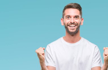 İzole arka plan kutlama üzerinde genç yakışıklı adam şaşırttı ve başarı için kaldırdı kollarını açarak hayret ve gözleri açık. Kazanan kavramı.