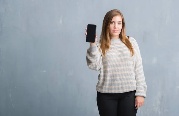 Jonge Volwassen Vrouw Grijs Grunge Muur Weergegeven Leeg Scherm Van — Stockfoto