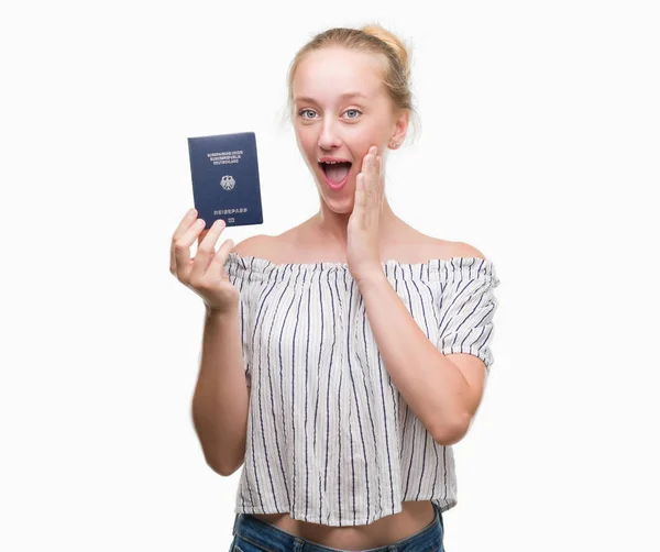 Nastolatek Blondynka Kobieta Gospodarstwa Paszport Niemiec Przestraszony Szoku Ścianą Niespodzianka — Zdjęcie stockowe