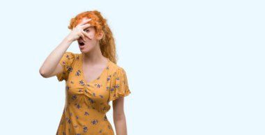 Yüz ve gözler el ile kapsayan şok bakmak genç Kızıl saçlı kadın mahcup ifadeyle parmaklarımın arasından arıyor.