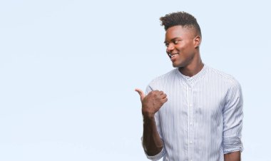 Genç Afro-Amerikan adam arıyor ve başparmak yanında yukarıyı mutlu yüz ile gülümseyen izole arka plan üzerinde.