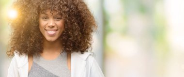 Mutlu yüz ayakta ile eğitim ve diş gösterilen kendine güvenen bir gülümsemeyle gülümseyerek Afro-Amerikan fitness kadın