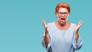 Atrractive üst düzey beyaz Kızıl saçlı kadın üzerinde gözlük takan arka plan deli izole ve deli bağırarak ve agresif ifade ve silah kaldırdı bağırıyor. Hayal kırıklığı kavramı.