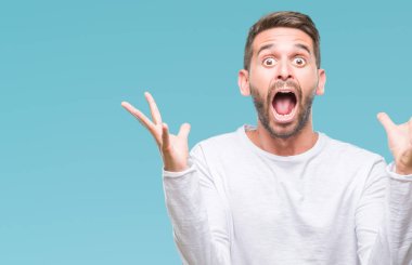 Yakışıklı delikanlı deli kutluyor ve silah ile başarı için heyecanlı çığlık kaldırdı ve açık gözleri hayret izole arka plan üzerinde. Kazanan kavramı